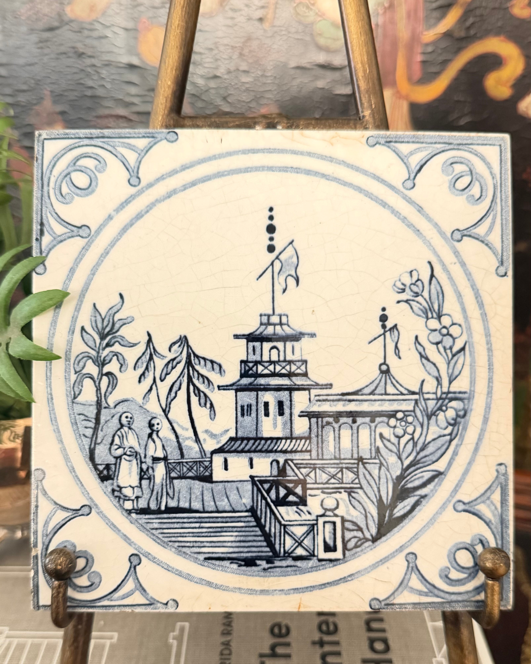 Close view of an antique Minton blue-and-white tile depicting figures beside a Chinoiserie pavilion
