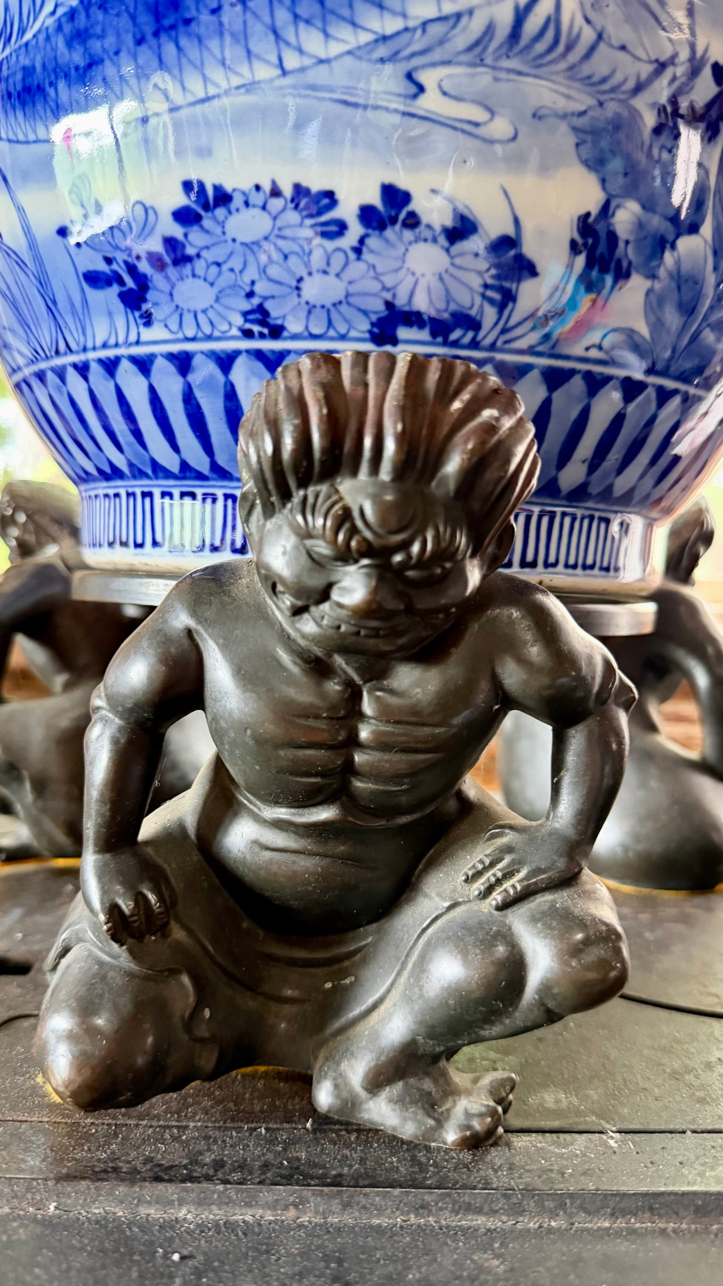 Close-up of a crouching bronze figure from the Japanese jardinière stand.