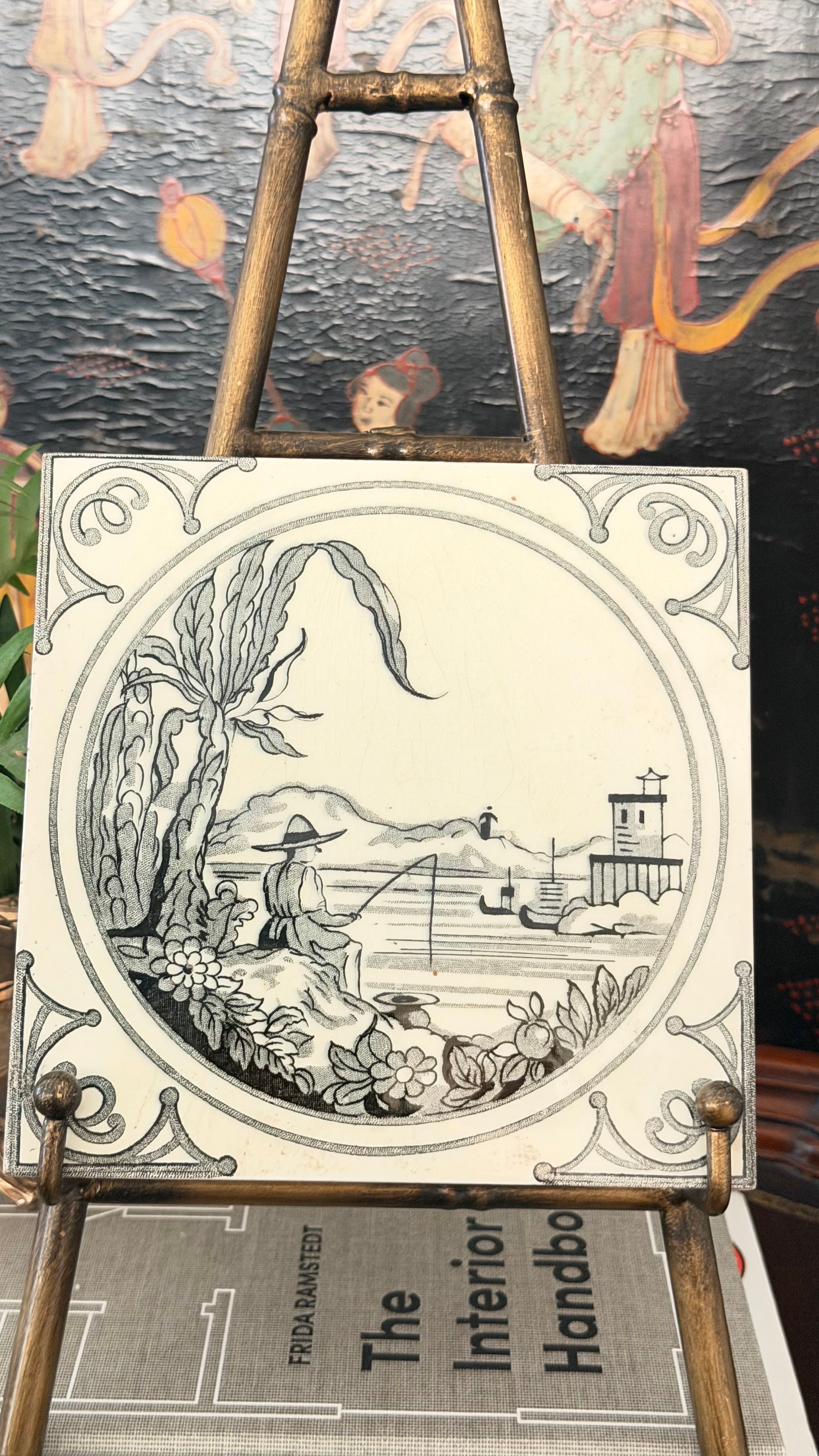 Close view of antique Minton tile with black Chinoiserie fisherman landscape