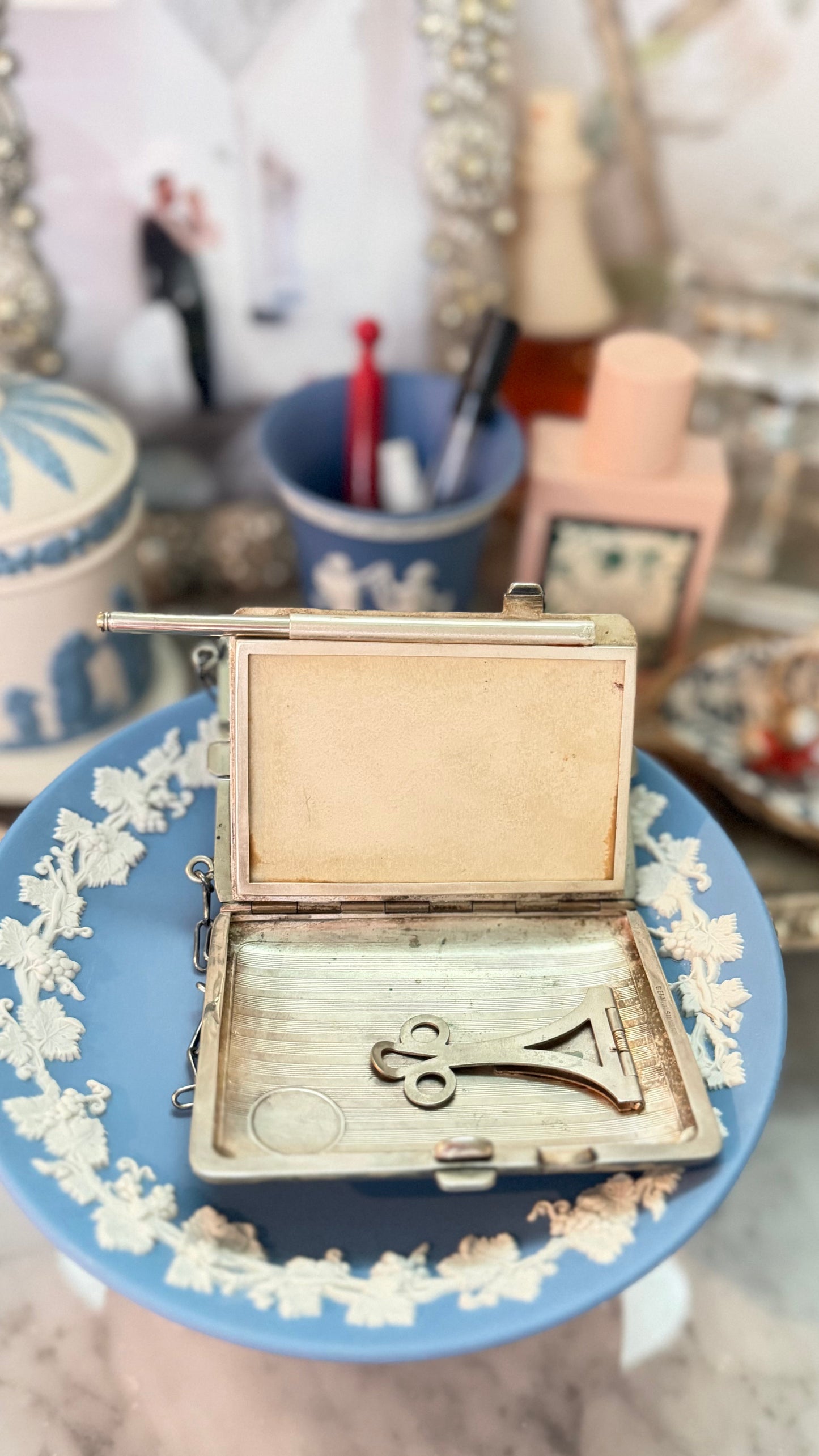 Antique German-silver dance purse open to show writing surface, partially extended pencil, and interior money clip.