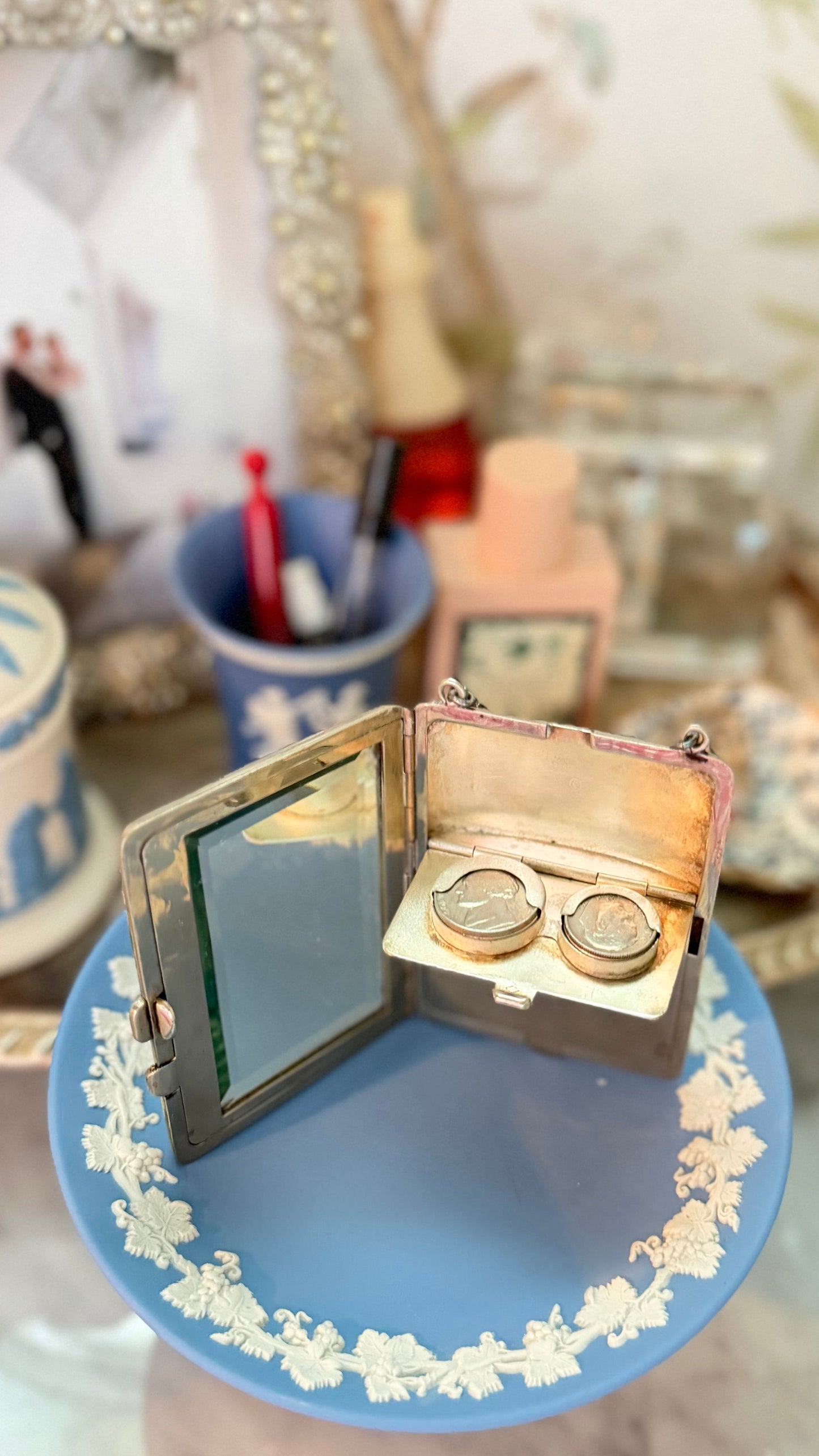 Antique German-silver three-compartment dance purse open to show its beveled mirror and two mechanical coin holders.