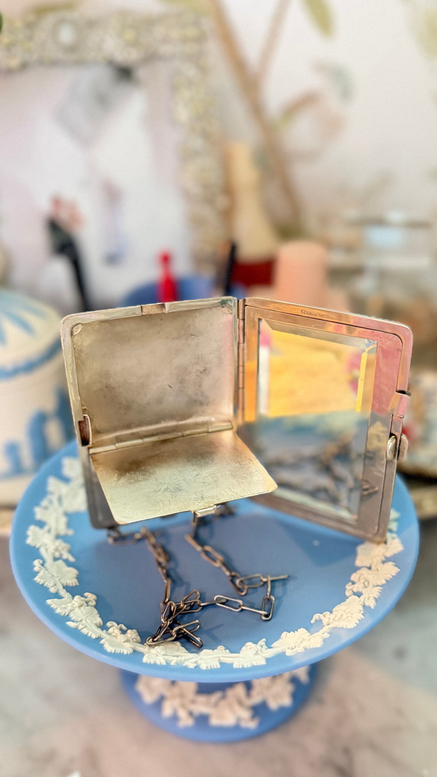 Antique German-silver dance purse open to show its beveled mirror and likely hinged powder compartment.