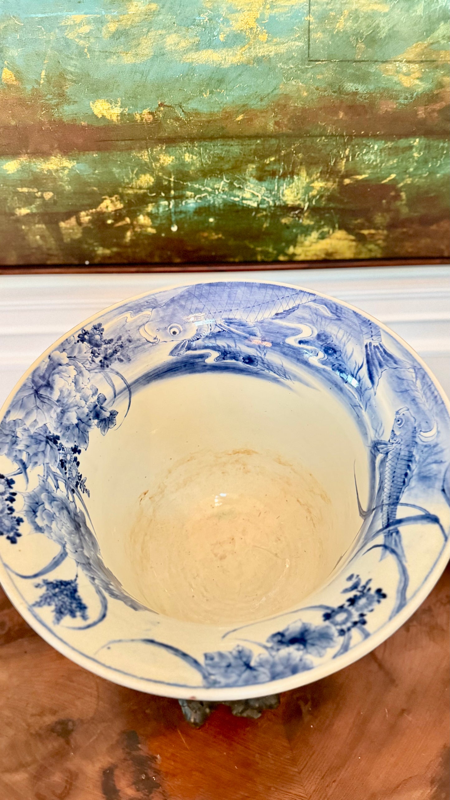 Interior of a Japanese blue-and-white jardinière painted with koi, flowers, and aquatic plants.
