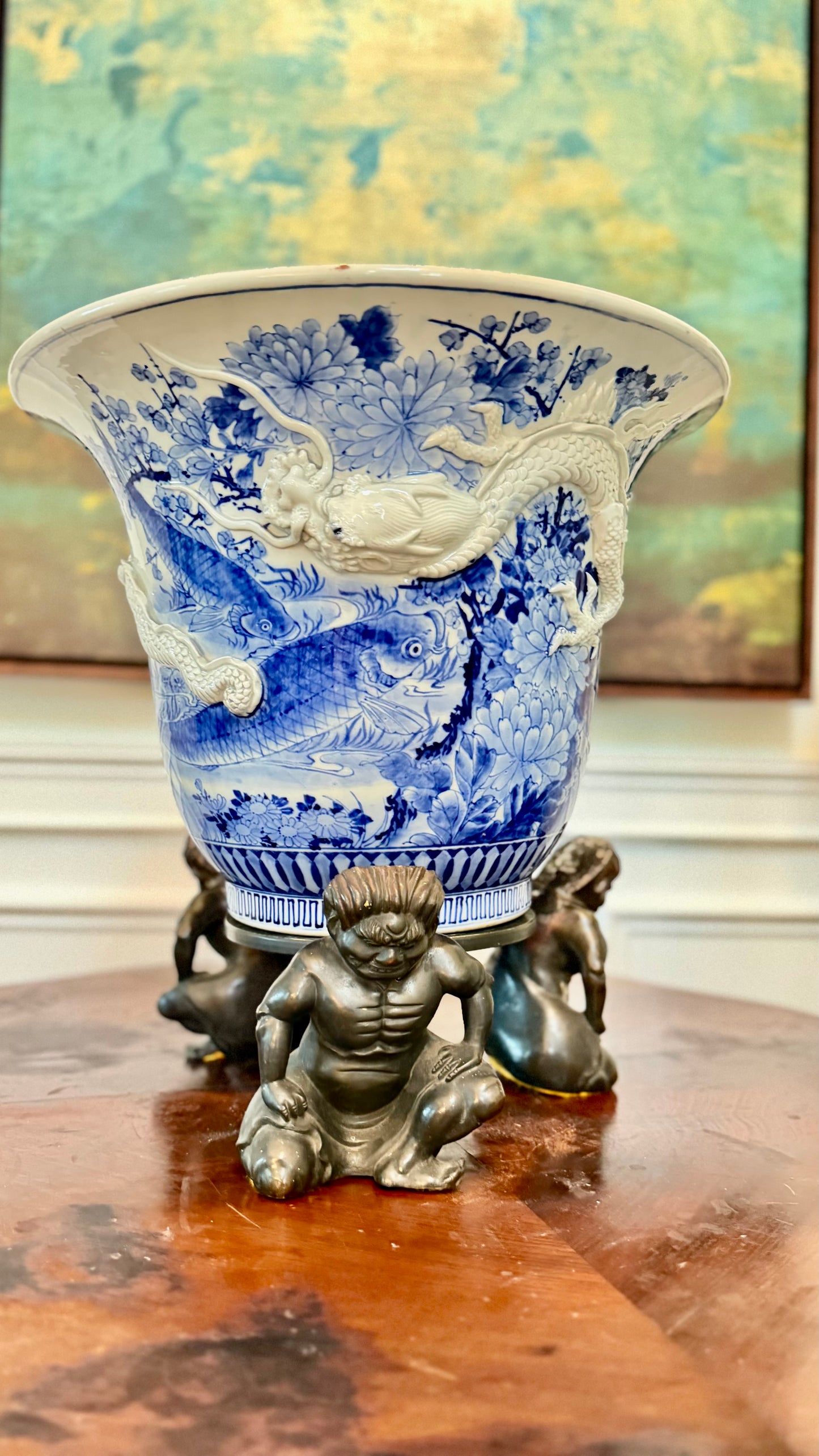 Antique Japanese blue-and-white dragon jardinière on a three-figure bronze stand.