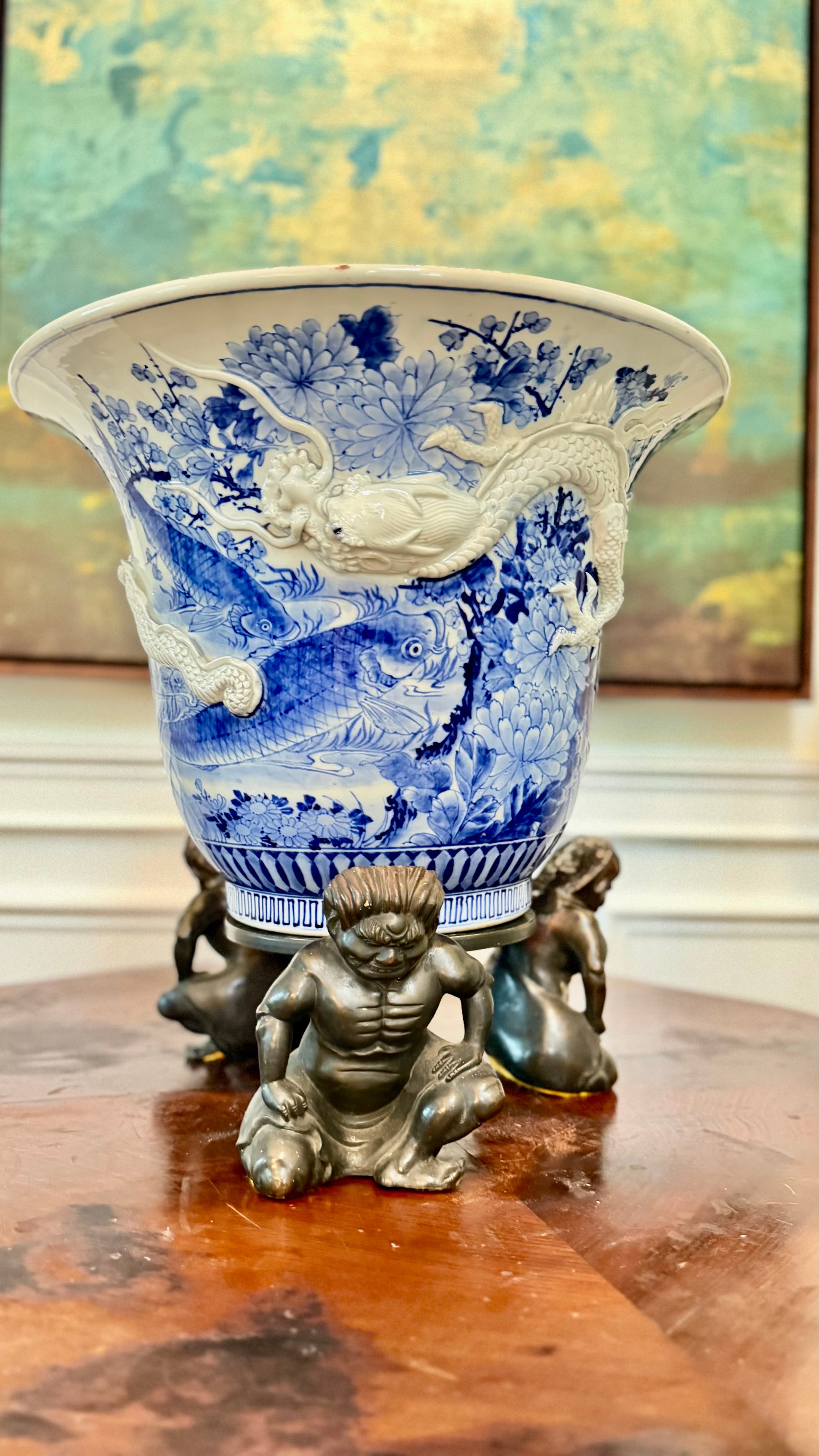 Antique Japanese blue-and-white dragon jardinière on a three-figure bronze stand.