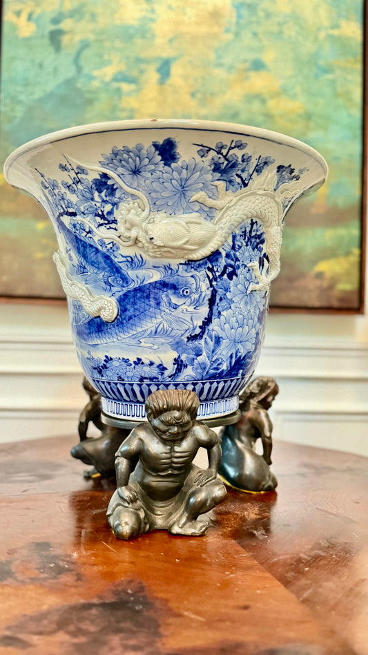 Antique Japanese blue-and-white dragon jardinière on a three-figure bronze stand.