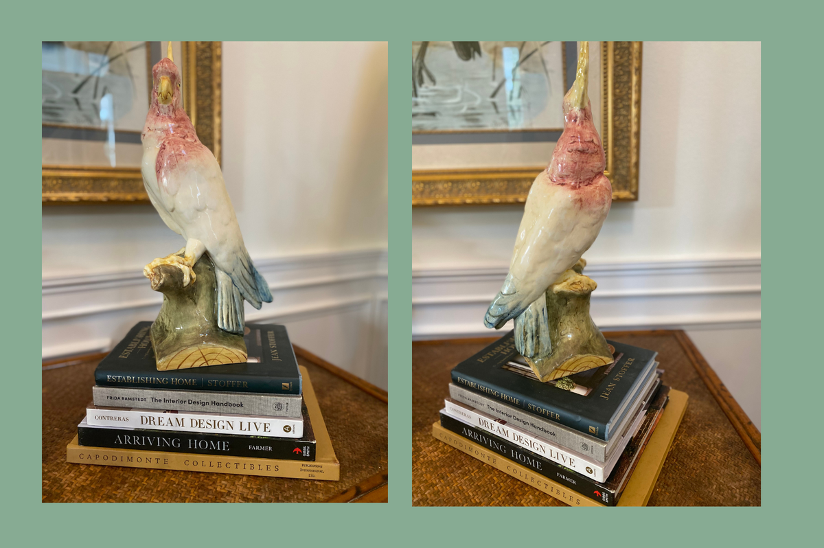 Antique Royal Dux cockatoo figurine styled on stacked interior-design books.