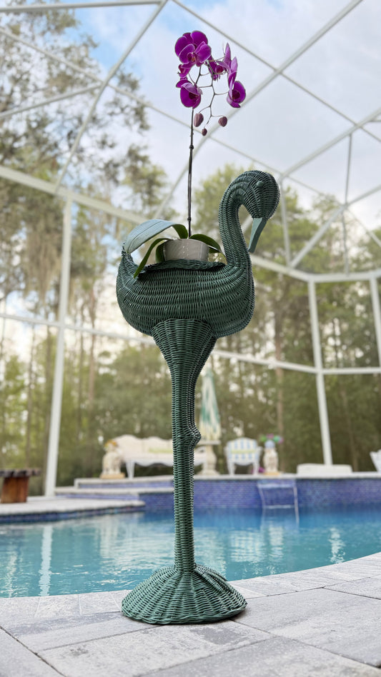 Vintage 39-inch wicker flamingo plant stand in Messel green styled with a magenta orchid beside a swimming pool